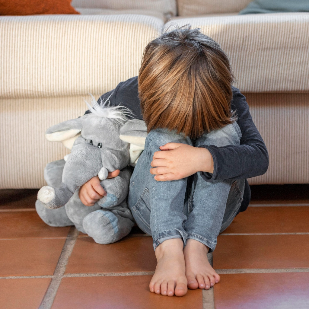 Niño abrazando su peluche mientras aprende a gestionar emociones con apoyo psicológico