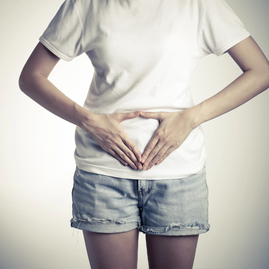 Mujer tocando su abdomen para representar molestias o disfunciones del suelo pélvico tratadas con fisioterapia en Vallirana