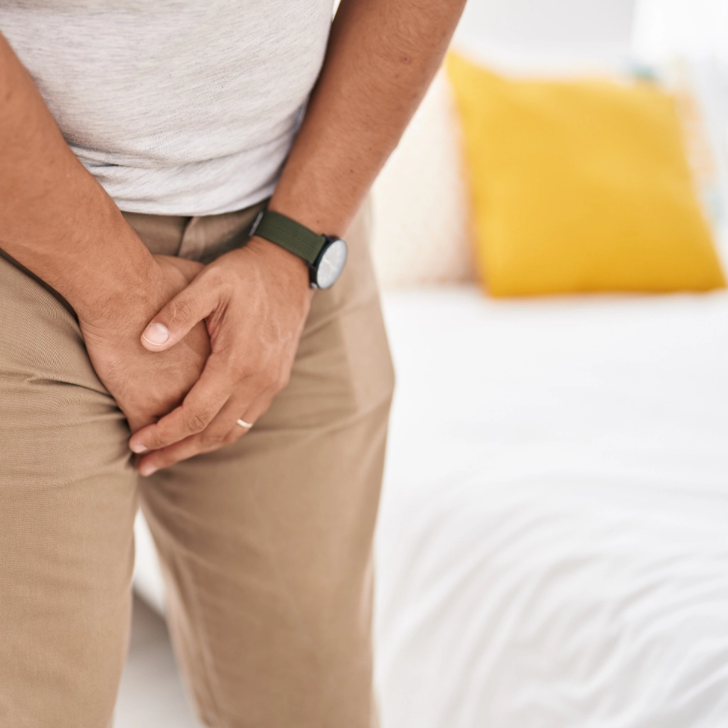 Hombre sujetándose la pelvis por molestias urinarias o dolor pélvico masculino