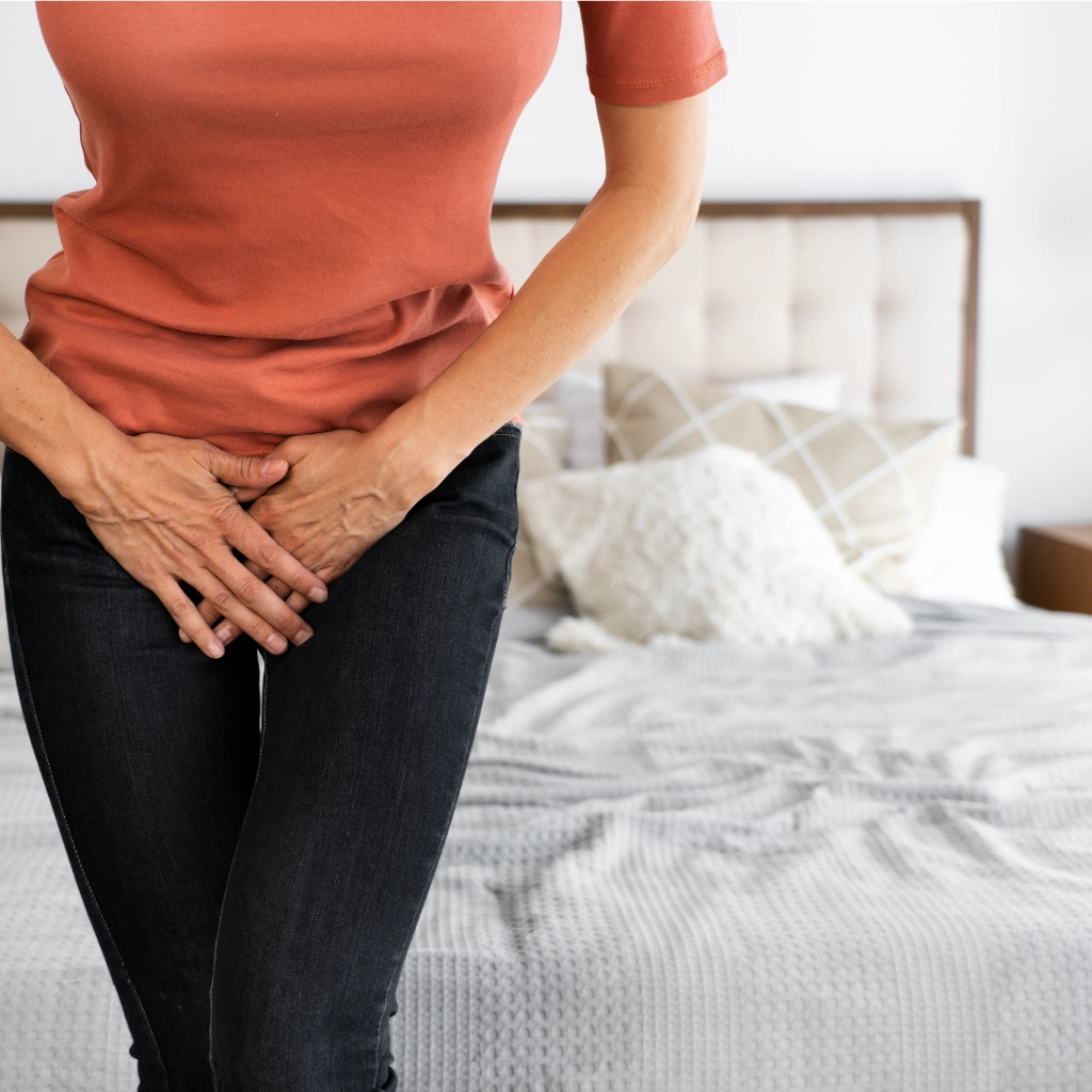 Mujer en menopausia sujetándose la zona pélvica por molestias urinarias o presión vaginal