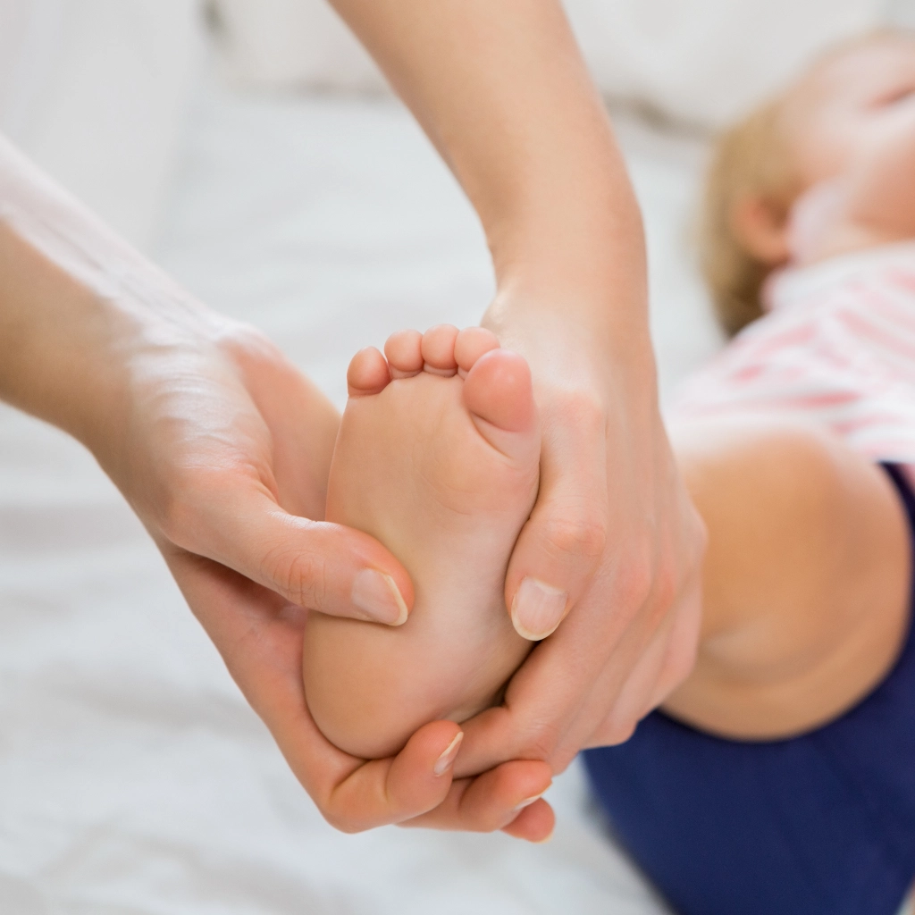 Bebé realizando ejercicios de fisioterapia neuromotriz para estimular el desarrollo motor y la coordinación con acompañamiento profesional.