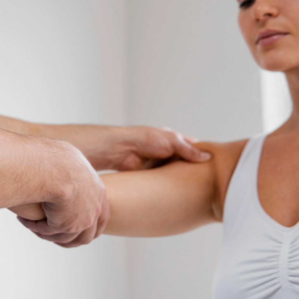 Evaluación y estiramiento del brazo de una paciente durante sesión de fisioterapia deportiva
